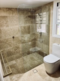 a bathroom with a glass shower stall and toilet